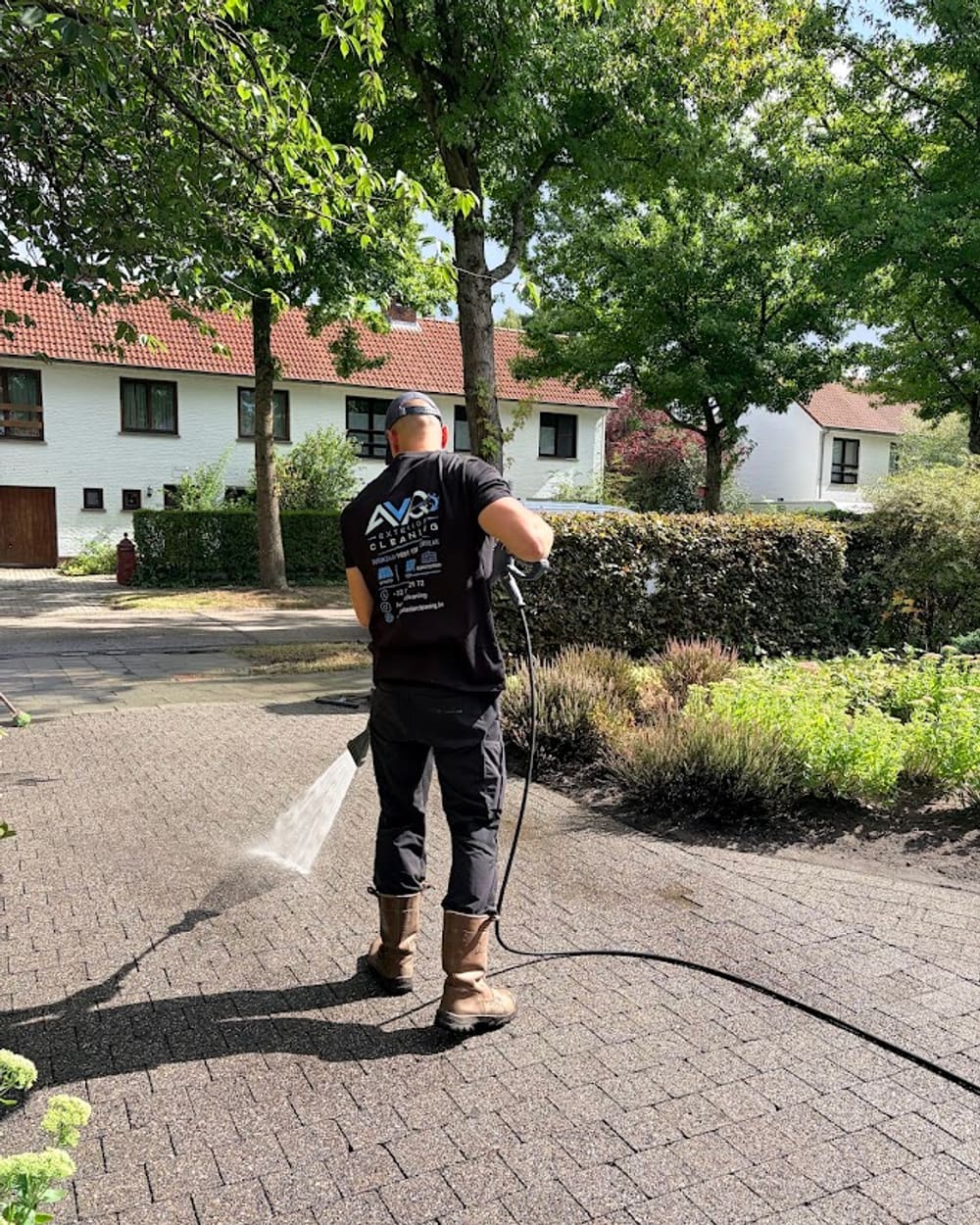 Anthony van AVQ Exterior Cleaning reinigt een klinkeroprit met een hogedruklans.
